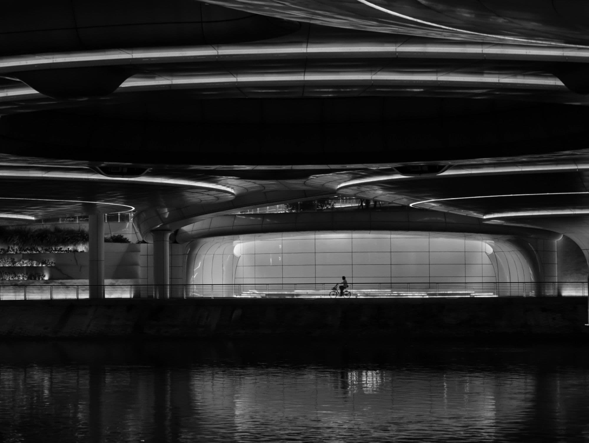 Estrutura arquitetônica curva com interior iluminado à noite